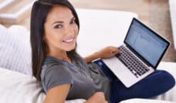 Working on my blog. Portrait of an attractive young woman using her laptop at home