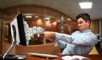 Businessman pulling out money of the computer screen for earning multiple income streams